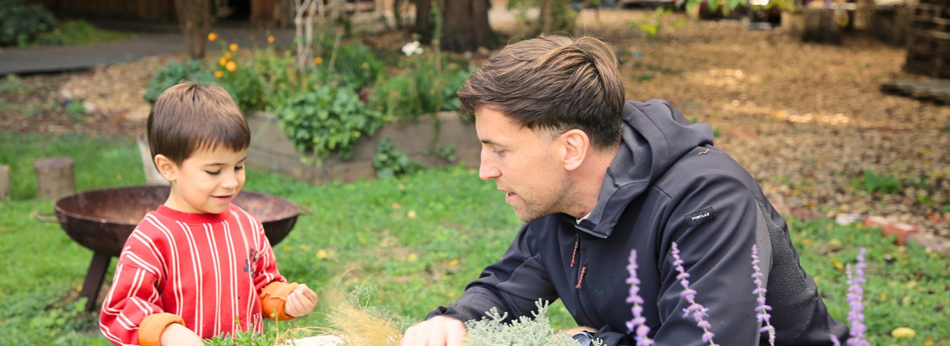 Teacher, Charlie, with a nursery student in the garden
