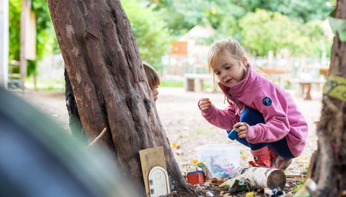 Nursery children playing outdoors under trees