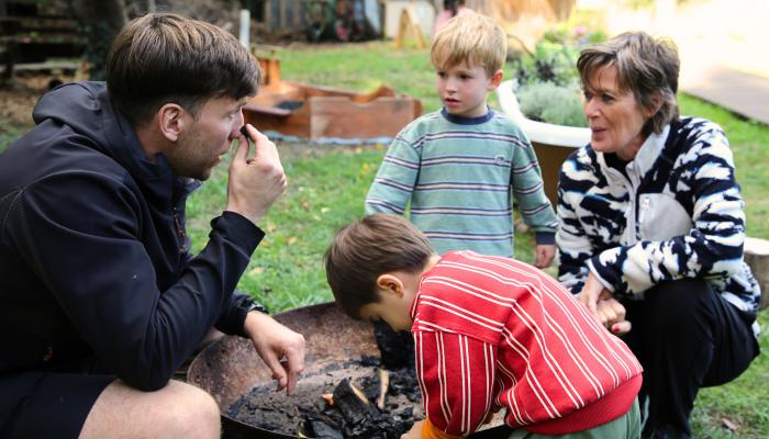 Teachers, Becky and Charlie by the empty fire pit with two nursery students