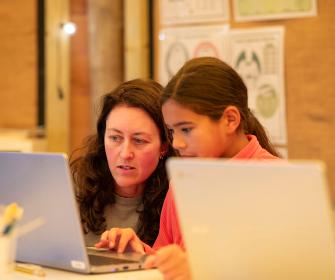 Liberty Primary Student and Teacher looking at a computer screen