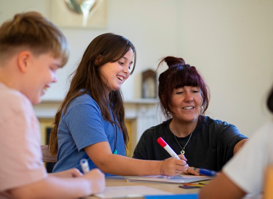 Child and teacher at a desk looking at work