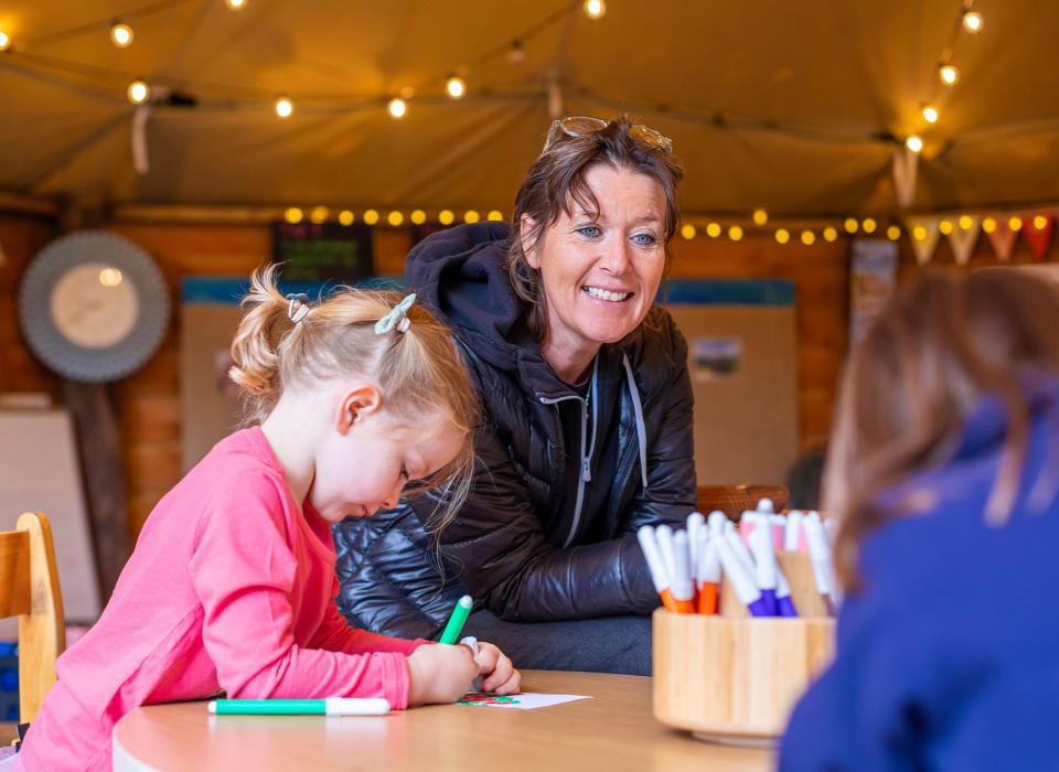Nursery teacher with learners in outdoor classroom