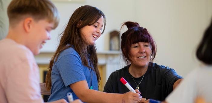 Child and teacher at a desk looking at work